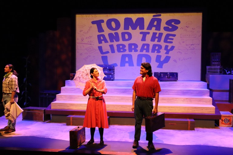 Two actors stand on stage in front of a screen that says Tomás and the Library Lady