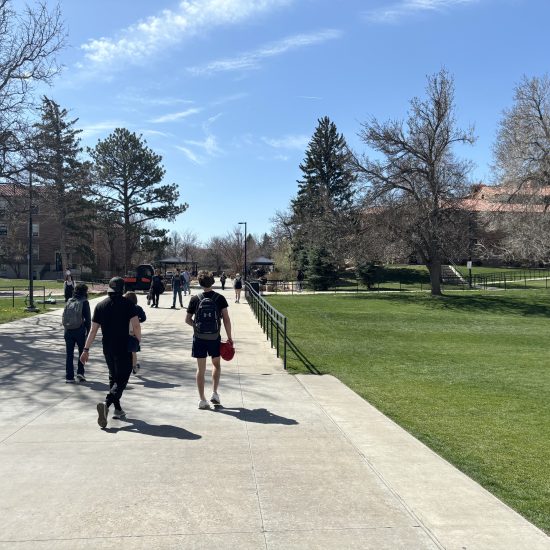 Students walk on a sidewalk on CU Boulder cmapus.